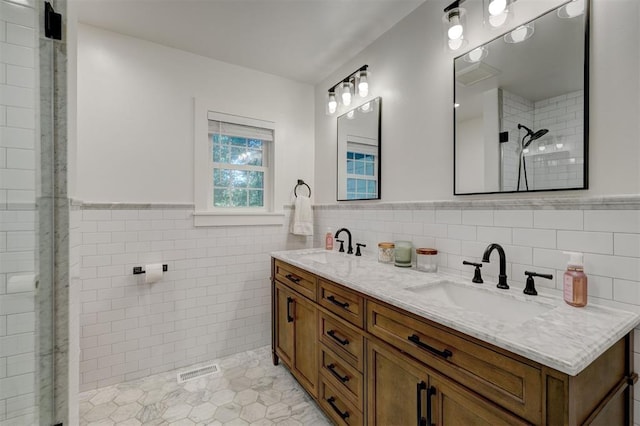 bathroom with tiled shower, tile walls, a sink, and visible vents