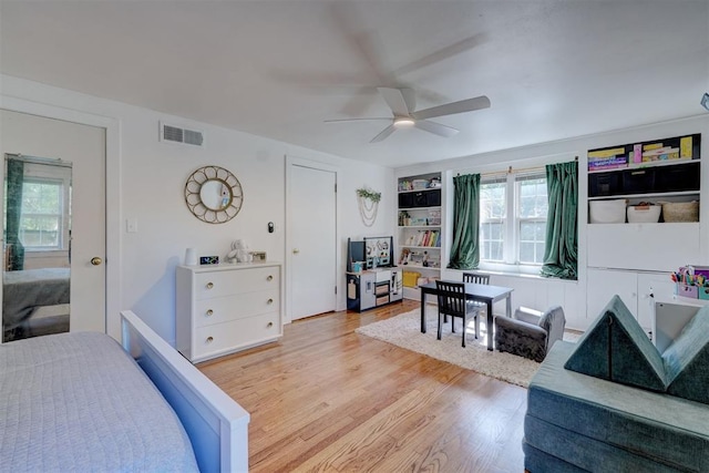 bedroom with visible vents, a ceiling fan, light wood-style floors, and multiple windows