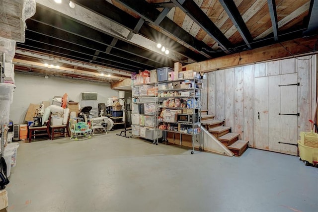 unfinished basement featuring wood walls