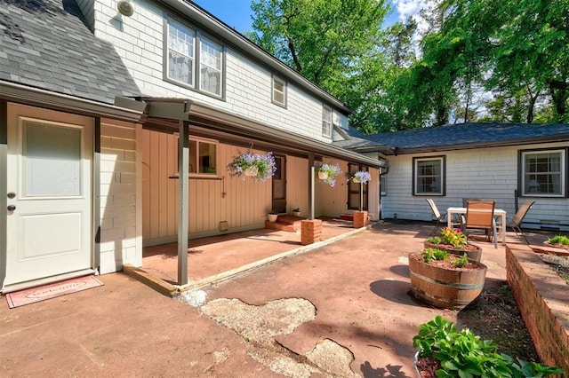 back of house featuring a shingled roof and a patio area