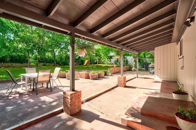 view of patio with a fenced backyard, a playground, and outdoor dining space
