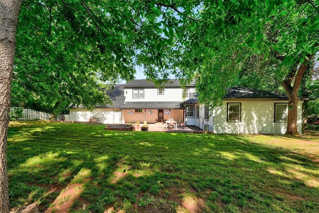 back of property featuring fence, a yard, and a patio area