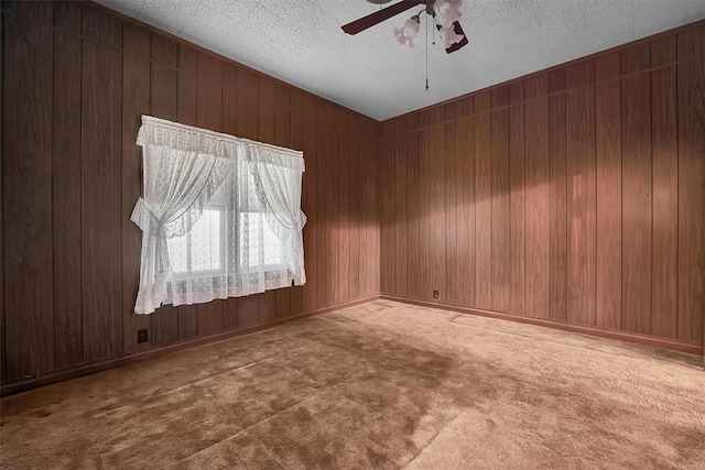 carpeted empty room featuring wooden walls and ceiling fan