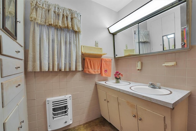 bathroom with double vanity, tile walls, tasteful backsplash, a sink, and heating unit