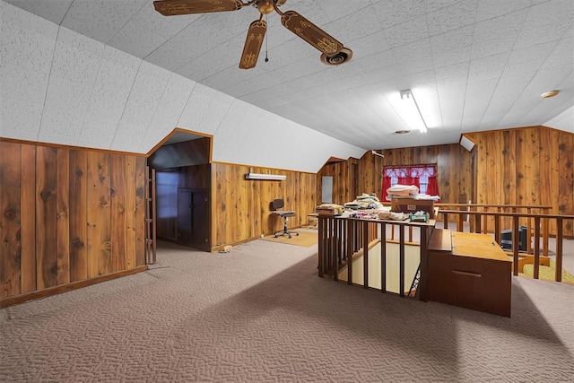 bonus room featuring wooden walls, ceiling fan, vaulted ceiling, and carpet