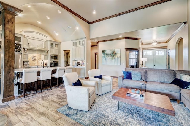 living room with arched walkways, ornamental molding, baseboards, and vaulted ceiling