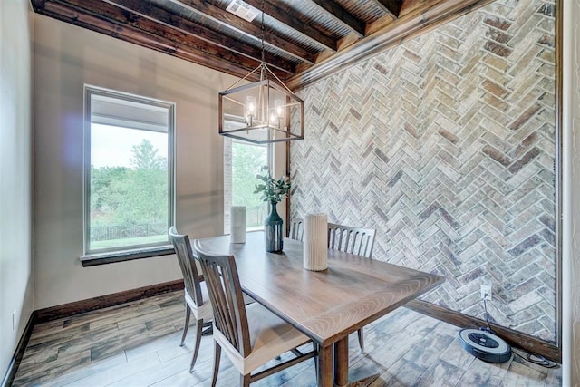 dining area featuring wood finished floors, beamed ceiling, baseboards, wood ceiling, and a chandelier