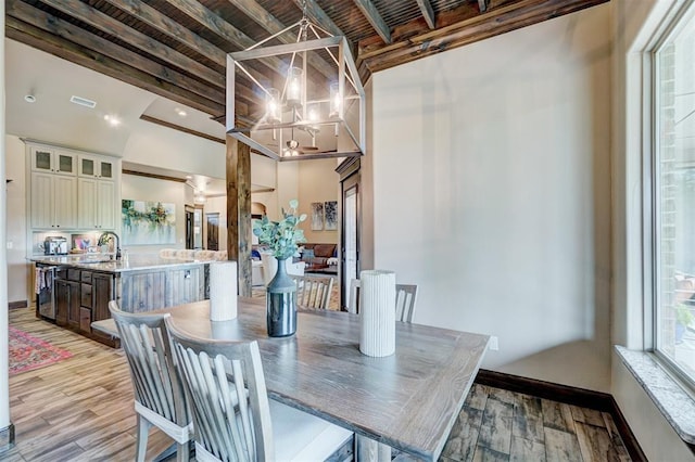dining space with baseboards, light wood-style flooring, a notable chandelier, and visible vents