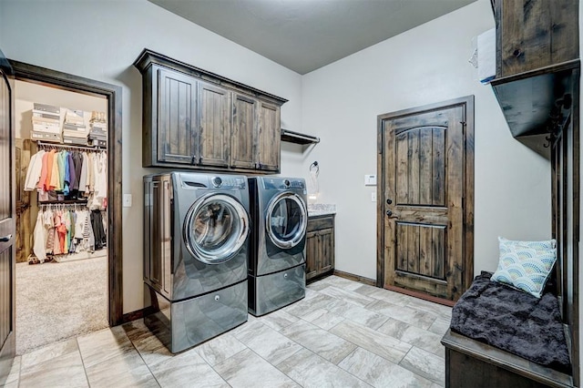 laundry area featuring baseboards, cabinet space, and washer and dryer