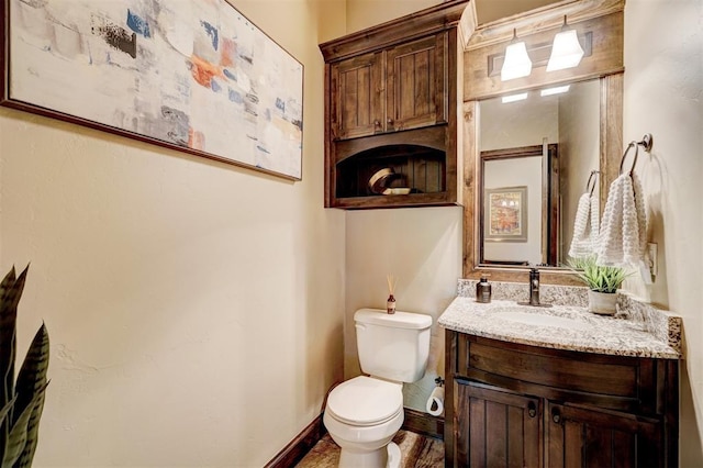 bathroom featuring vanity, baseboards, and toilet