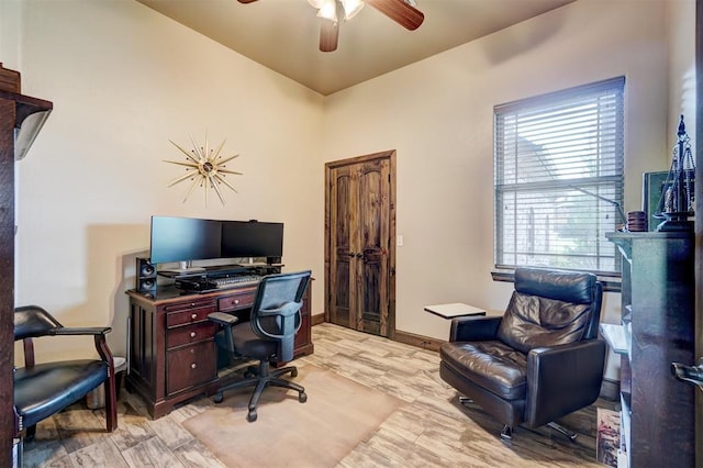 office space with baseboards, ceiling fan, and light wood-type flooring