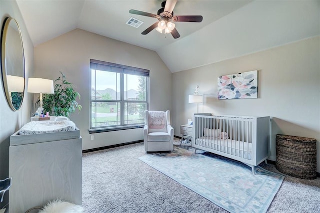 bedroom featuring a ceiling fan, a crib, carpet, and vaulted ceiling
