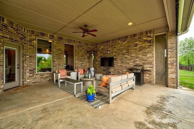 view of patio featuring fence, ceiling fan, an outdoor living space, and grilling area
