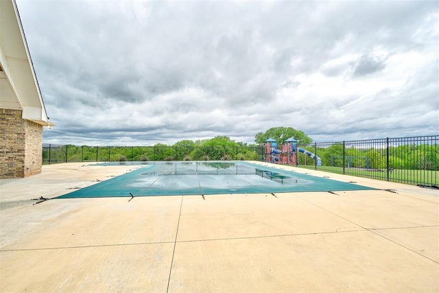 pool featuring a patio, fence, and playground community