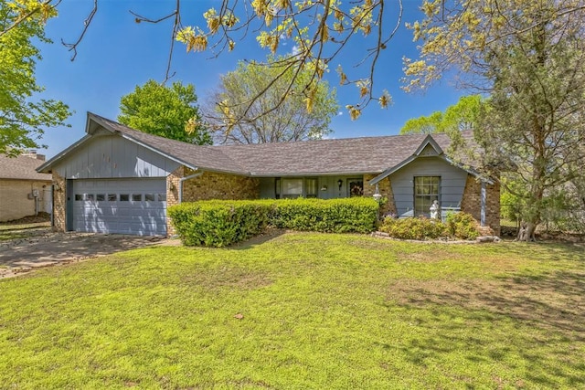 single story home with a garage, a front yard, driveway, and brick siding