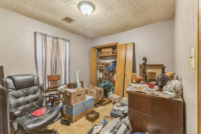 interior space with visible vents, carpet, a textured ceiling, and a textured wall