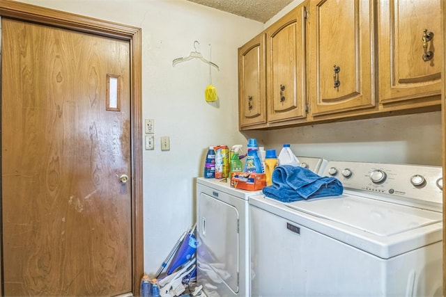 washroom with cabinet space, separate washer and dryer, and a textured ceiling