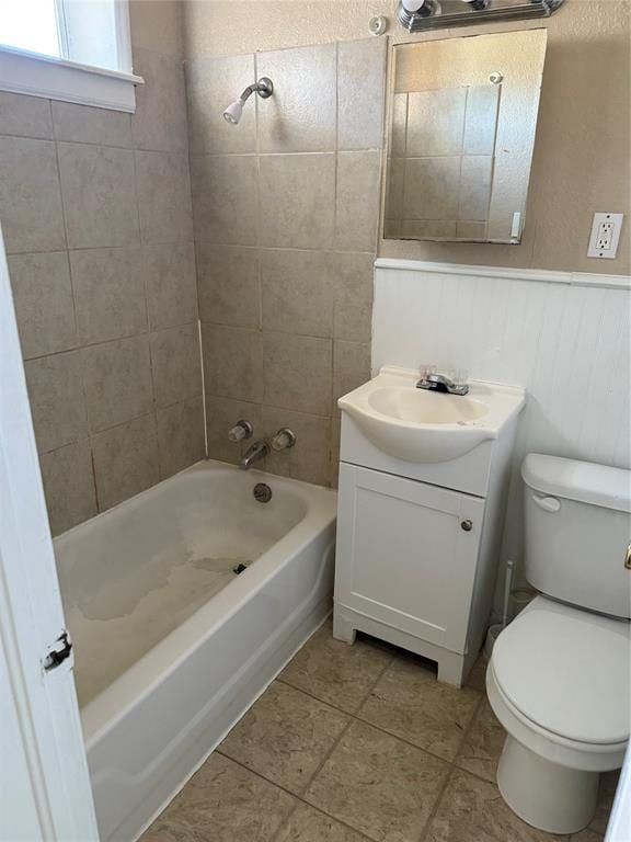 bathroom featuring shower / bath combination, wainscoting, tile patterned floors, vanity, and toilet