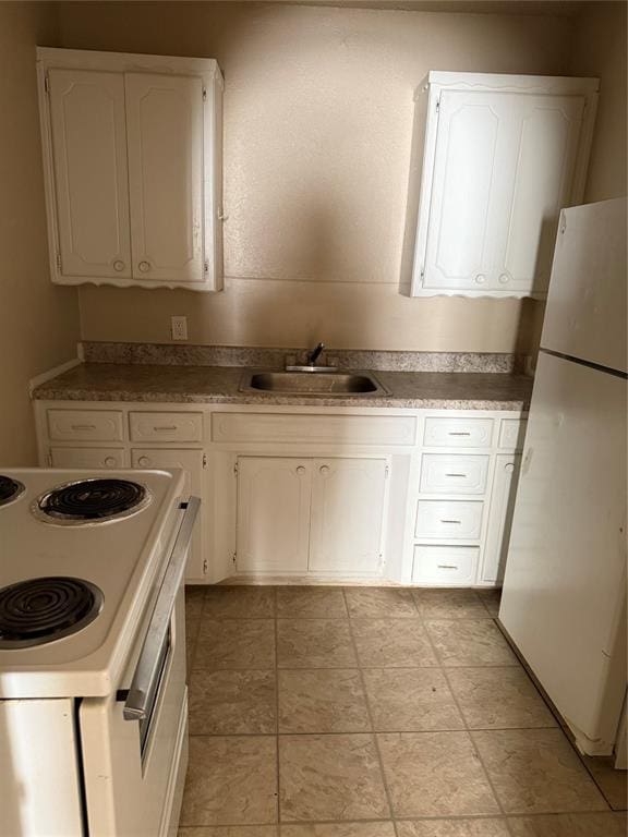 kitchen with a sink, white cabinets, and white appliances