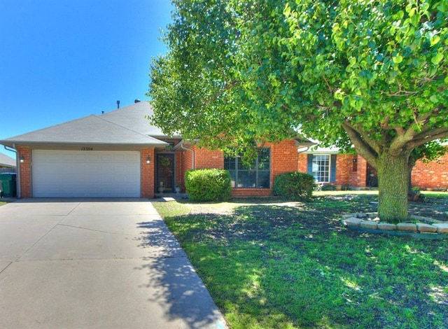 view of front of property with an attached garage, concrete driveway, a front lawn, and brick siding