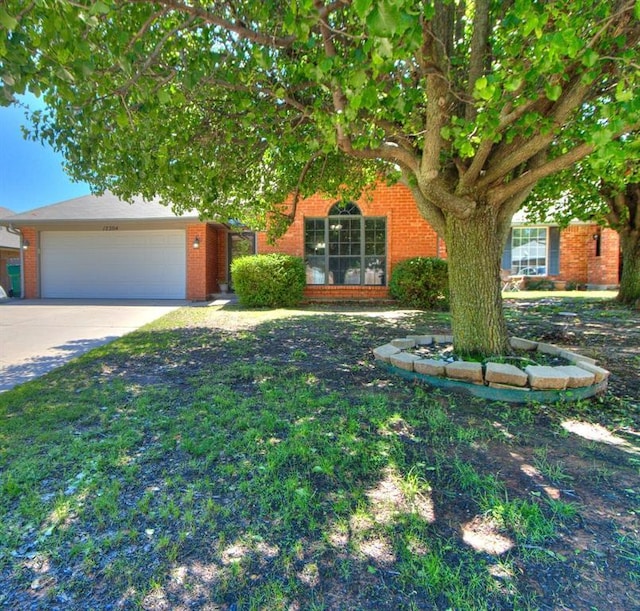 obstructed view of property with concrete driveway, brick siding, and an attached garage