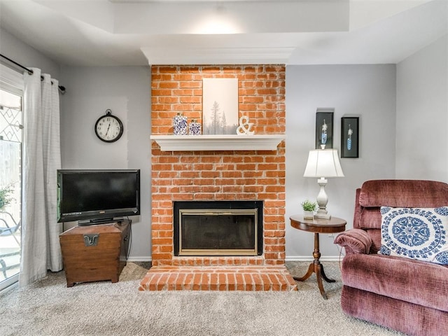 carpeted living area with baseboards and a brick fireplace