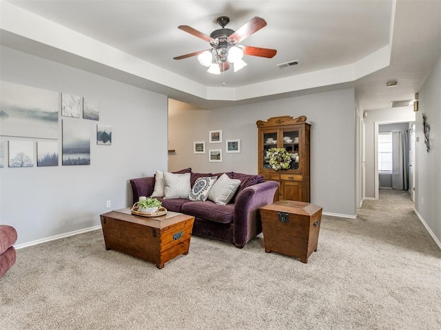 living area featuring ceiling fan, light colored carpet, baseboards, and visible vents