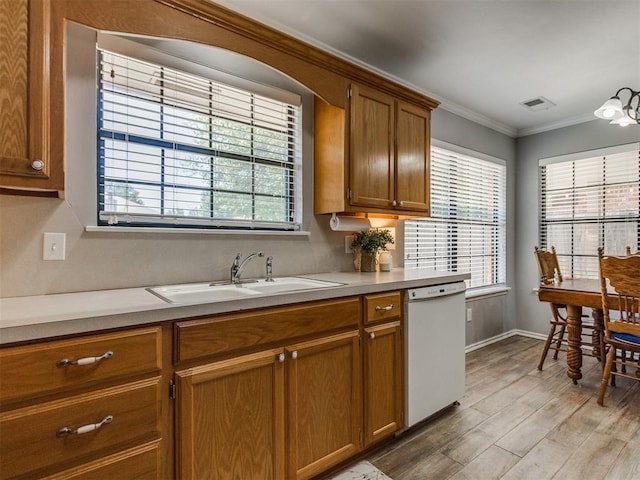 kitchen with brown cabinetry, dishwasher, a sink, light countertops, and light wood-style flooring