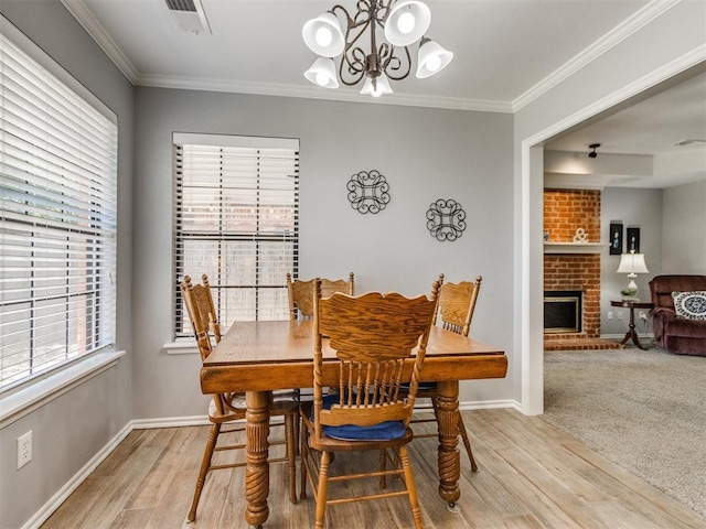 dining area featuring an inviting chandelier, light wood finished floors, and crown molding