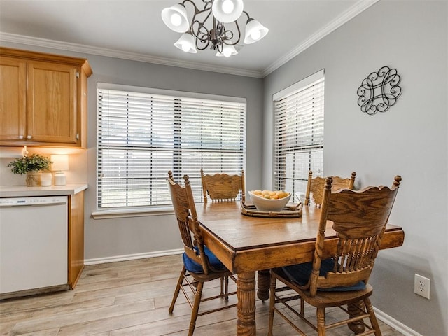 dining room featuring baseboards, ornamental molding, light wood finished floors, and a notable chandelier