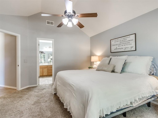bedroom with light carpet, baseboards, ensuite bathroom, lofted ceiling, and visible vents