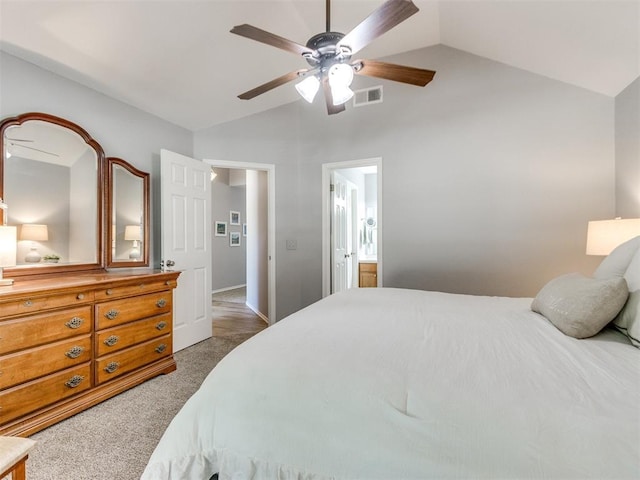 bedroom with a ceiling fan, visible vents, carpet floors, lofted ceiling, and ensuite bathroom