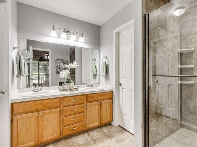 ensuite bathroom featuring double vanity, tile patterned floors, a shower stall, and a sink