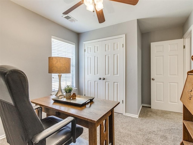 office area featuring visible vents, a ceiling fan, baseboards, and light carpet