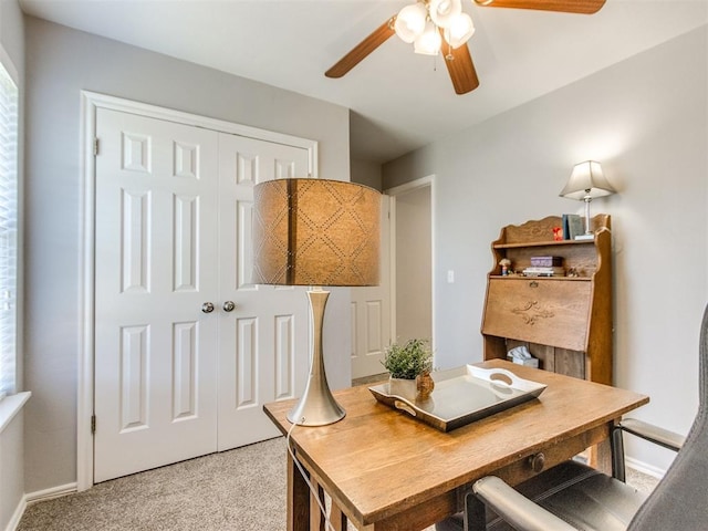 office featuring baseboards, light carpet, and a ceiling fan