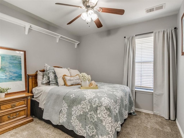 carpeted bedroom featuring visible vents, a ceiling fan, and baseboards
