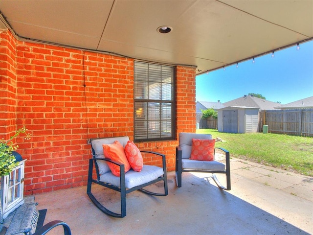 view of patio featuring fence, an outbuilding, and a shed