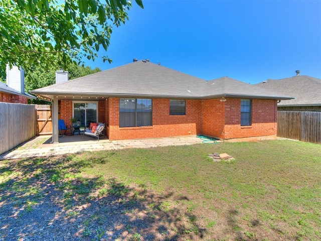back of property with a patio, a fenced backyard, a chimney, and brick siding
