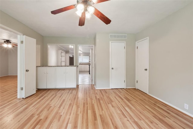 2417 NW 55th Ter, Oklahoma City, OK 73112 - unfurnished living room featuring a ceiling fan, baseboards, visible vents, and light wood-style floors