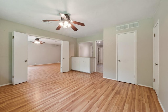 2417 NW 55th Ter, Oklahoma City, OK 73112 - unfurnished living room with ceiling fan, visible vents, baseboards, and light wood-style floors