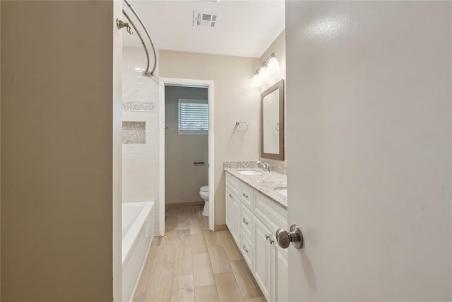 2417 NW 55th Ter, Oklahoma City, OK 73112 - bathroom with visible vents, a sink, double vanity, and toilet