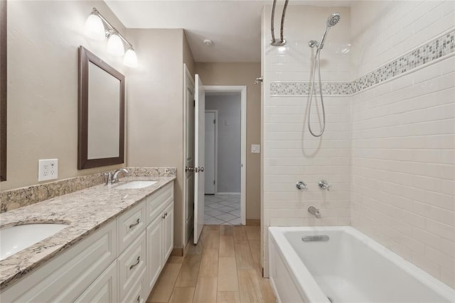 2417 NW 55th Ter, Oklahoma City, OK 73112 - full bathroom with double vanity, a sink, wood finished floors, and bathing tub / shower combination