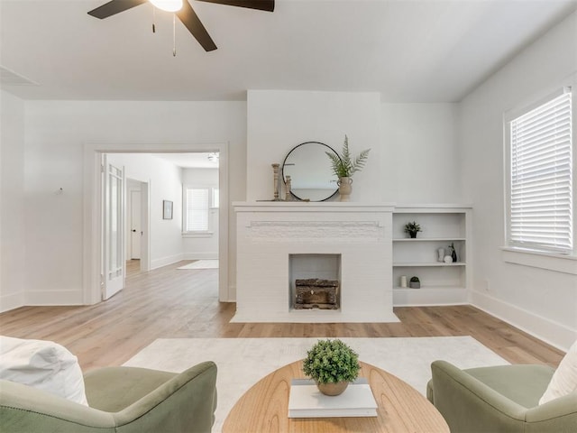 1132 NE 17th St, Oklahoma City, OK 73111 - living area featuring baseboards, ceiling fan, wood finished floors, and a fireplace