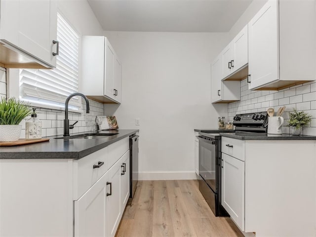 1132 NE 17th St, Oklahoma City, OK 73111 - kitchen featuring dark countertops, stainless steel dishwasher, black electric range oven, a sink, and light wood-style floors