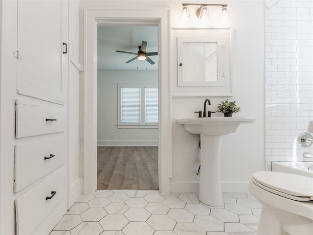1132 NE 17th St, Oklahoma City, OK 73111 - bathroom featuring baseboards, a ceiling fan, and toilet