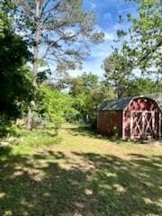 view of yard featuring a storage shed and an outdoor structure