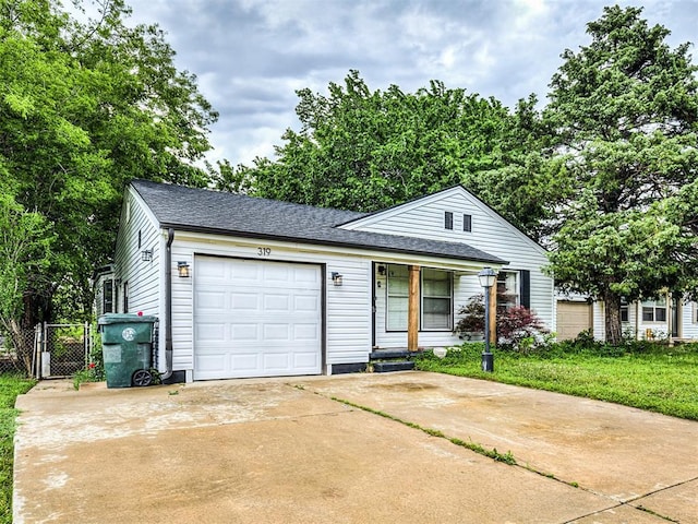 view of front of property featuring fence, roof with shingles, a gate, concrete driveway, and an attached garage