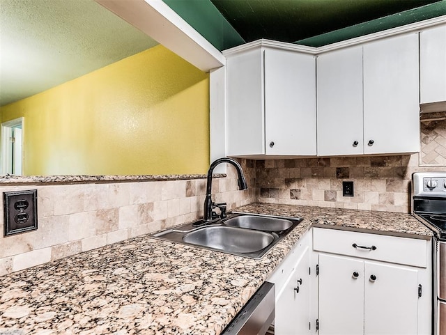 kitchen with a sink, decorative backsplash, and white cabinets