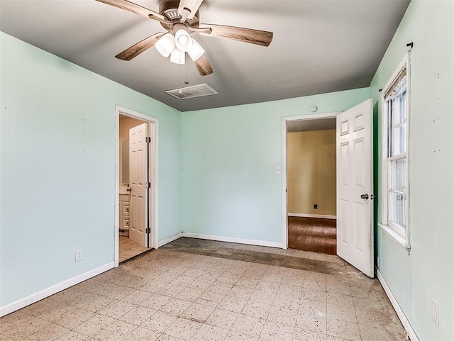 unfurnished bedroom featuring tile patterned floors, a ceiling fan, baseboards, ensuite bathroom, and visible vents