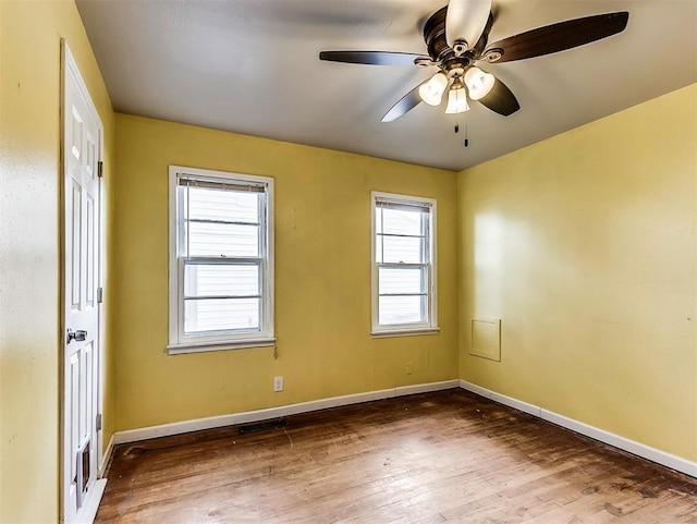 unfurnished room featuring baseboards, ceiling fan, wood finished floors, and visible vents